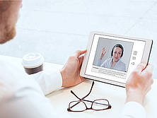 Mann mit Tablet in der Hand kommuniziert digital mit einer Mitarbeiterin
