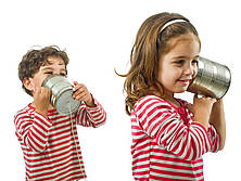 Zwei Kinder spielen mit einem Blechdosen-Telefon