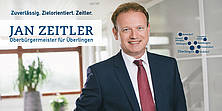 Titel einer Postkarte. Jan Zeitler, lächelnd in einem Bürogebäude. Daneben eine Grafik mit den Ortsteilen Überlingens.
